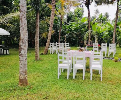 a table set up for a wedding with white chairs at Miracle Sand Country Resort in Mawatagama