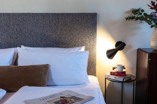 a bedroom with a bed with a book on it at Goldenstern Townhouse in Bolzano