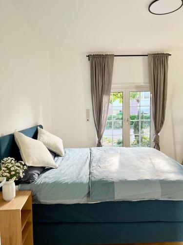 - une chambre avec un lit bleu et une fenêtre dans l'établissement Haus Neuss-EG, à Neuss