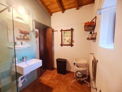 a bathroom with a sink and a mirror at Casa do Avô António in Bensafrim