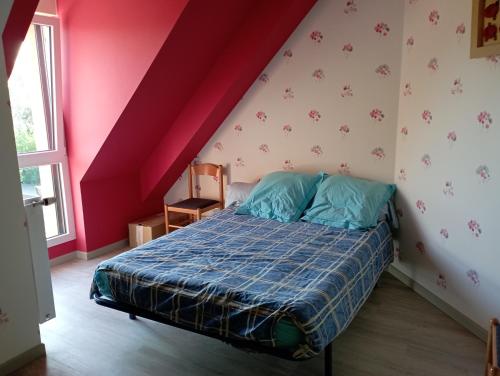 a bedroom with a bed and a red wall at Chambre proche du circuit 2415 route des vignes in Fillé