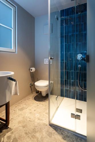 a bathroom with a toilet and a glass shower at Goldenstern Townhouse in Bolzano