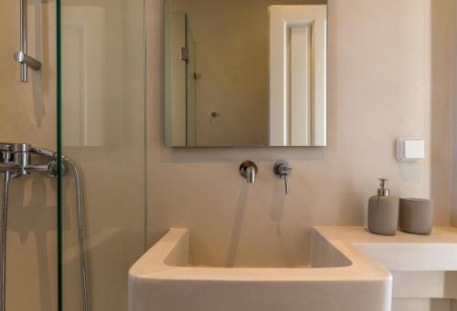 een badkamer met een wastafel en een douche bij La Chapelle Ouest & Guest suite in Agios Romanos