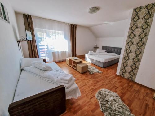 Habitación grande con 2 camas y sofá en Complex Caprioara Toplita en Topliţa