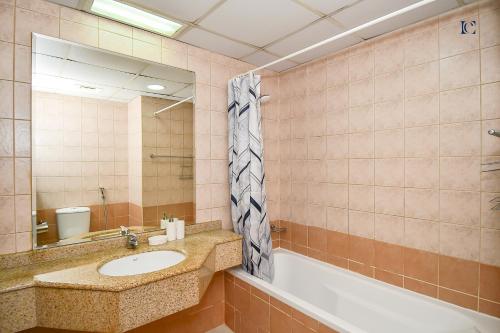 a bathroom with a sink and a tub and a mirror at Budget 1BR Apt in Marina - Near Tram & Metro -Time in Dubai