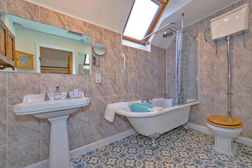 a bathroom with a sink and a tub and a toilet at Finest Retreats - Bakers Mews Cottage in Kimbolton