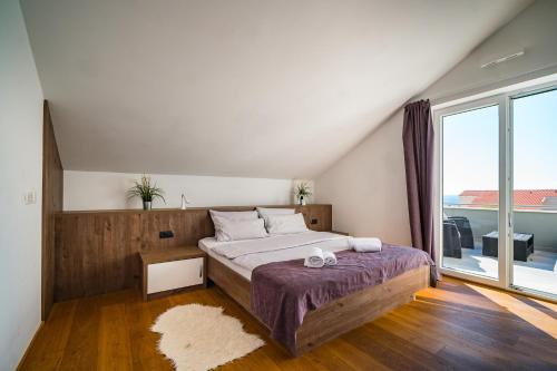 a bedroom with a large bed and a large window at Villa Flavia and Alba - Private Heated Pool in Novalja