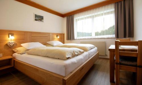 Un dormitorio con una cama grande y una ventana en Appartementhaus Daniel en Saalbach Hinterglemm
