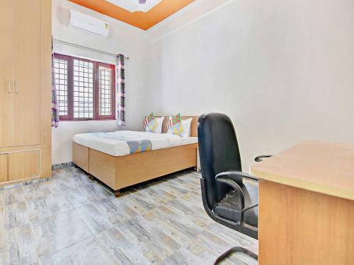 a room with a bed and a desk and a chair at HOME 78802 Balaji Bhawan Jhajra in Dehradun