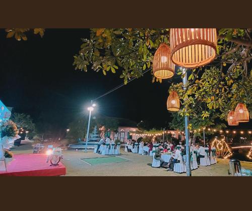 a group of tables and chairs in a park at night at Hoa Lu Garden Resort in Ninh Binh