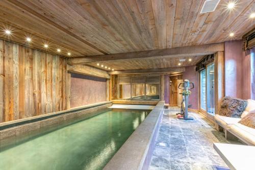 - une piscine intérieure dans une maison dotée d'un plafond en bois dans l'établissement Le Chalet à Val d'Isère, à Le Joseray
