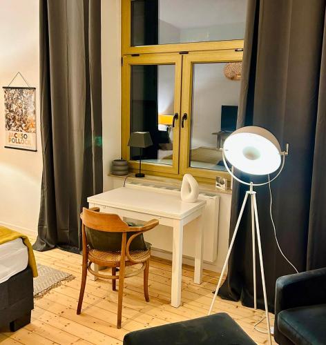 Cette chambre comprend un bureau avec une lampe et un miroir. dans l'établissement FeelsLikeHome - Stylische und zentrale Altbauwohnung mit Terrasse&Garten, à Bochum