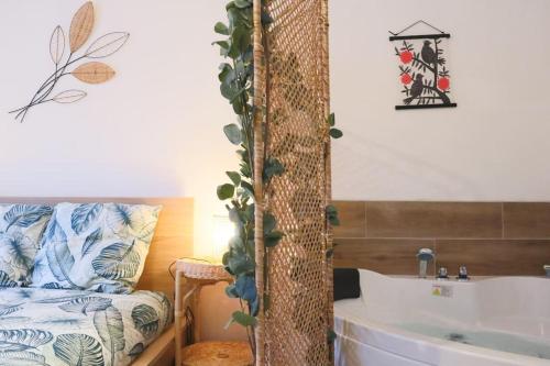 a bathroom with a bath tub next to a bed at Le Cocon Fleuri, proche centre in Mulhouse