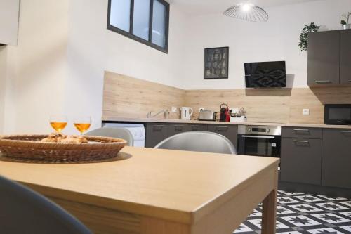 a kitchen with a table with two glasses of wine at Le Cocon Fleuri, proche centre in Mulhouse