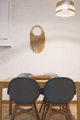 a table with two chairs and a basket on the wall at Le Cocon Fleuri, proche centre in Mulhouse