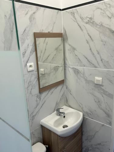 une salle de bain blanche avec un lavabo et un miroir dans l'établissement Beau petit studio avec terrasse et 2 couchages, à Fos-sur-Mer