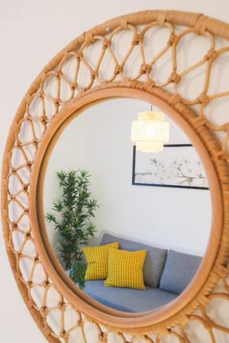 a mirror with a couch in a living room at Le Cocon Fleuri, proche centre in Mulhouse