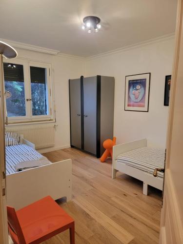 Cette chambre comprend deux lits et un grand réfrigérateur. dans l'établissement Villa de charme de 2 à 6 personnes, à Thyez