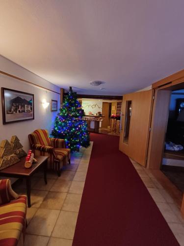 ein Weihnachtsbaum mitten im Wohnzimmer in der Unterkunft Hotel Restaurant Liesele Sonne in Sankt Leonhard im Pitztal