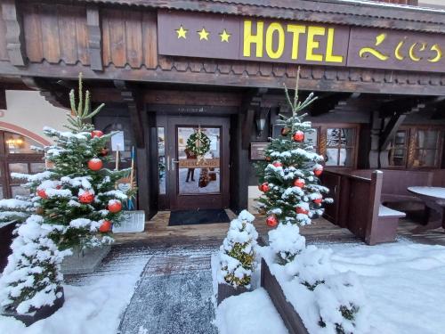 ein Hotel mit Weihnachtsbäumen davor in der Unterkunft Hotel Restaurant Liesele Sonne in Sankt Leonhard im Pitztal