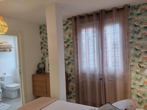 a bedroom with a sliding glass door with a toilet at Apartamento Casa Palabra in Santander