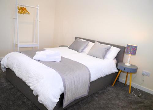 - une chambre avec un grand lit et des draps blancs dans l'établissement Craigielea Cottage, à Newton Stewart