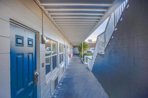 an empty hallway of a building with a blue door at Sunrise Inn by OYO Titusville FL in Titusville