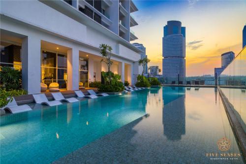a hotel swimming pool with chairs and a city skyline at Quill City Residences KLCC, Five Senses in Kuala Lumpur