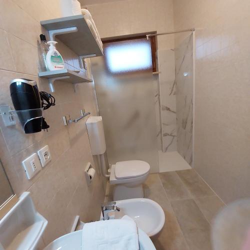 a bathroom with a toilet and a sink and a shower at B&B Cuei di Baret in Tricesimo
