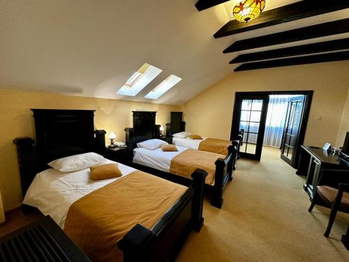 a hotel room with three beds in a room at Podu' cu Lanturi in Bacău