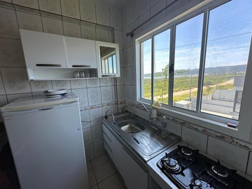 a small kitchen with a sink and a window at Villa Cavaliere in Palhoça