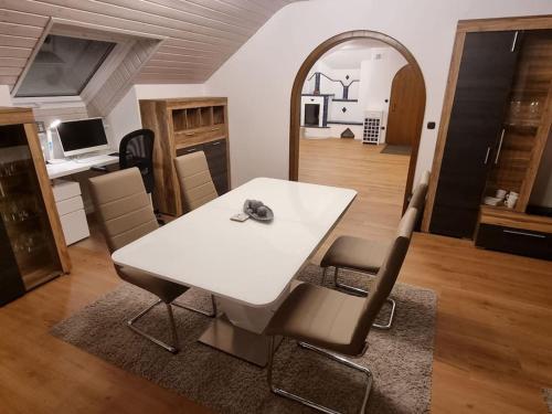 uma mesa branca e cadeiras numa sala de estar em Gemütliche Wohnung am Waldrand em Thierhaupten