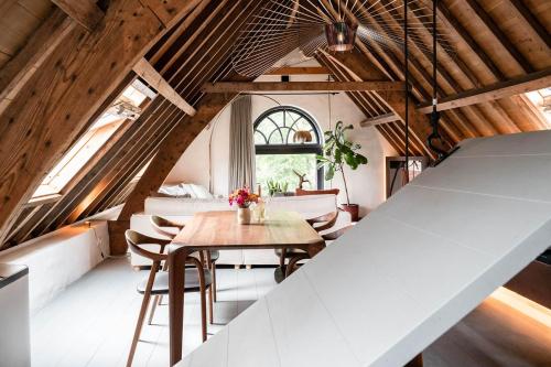 een zoldereetkamer met een tafel en stoelen bij Landgoed Huis te Jaarsveld 