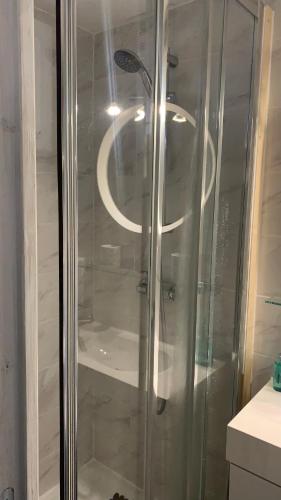 une douche avec une porte vitrée dans une salle de bain dans l'établissement Adorable studio 20m2, à Aubervilliers