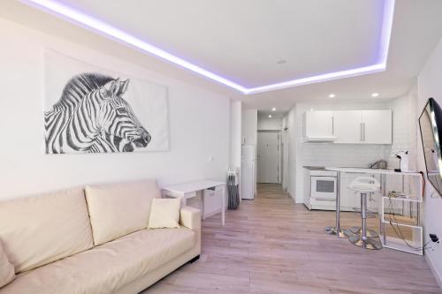 a living room with a couch and a painting of a zebra at Sun Apartments in Torremolinos