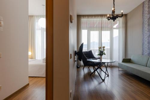 Le Port Boutique Apart Hotel في باتومي: غرفة معيشة مع أريكة زرقاء وطاولة