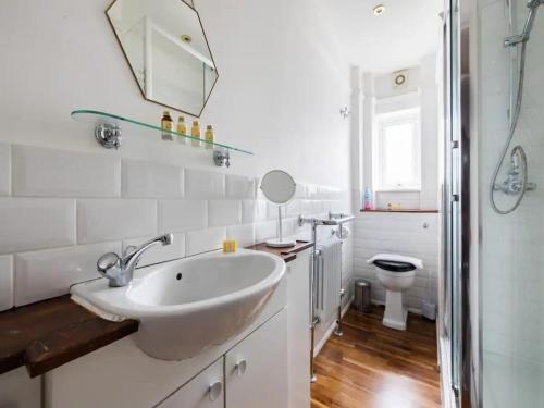 a white bathroom with a sink and a toilet at Pass the Keys Spacious and central 2 bedroom flat in Chelsea in London