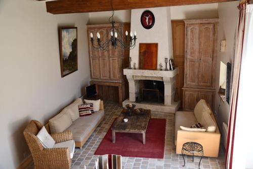 a living room with a couch and a fireplace at Les Haltes du Clos du Petit Dannezy in Cour-Cheverny