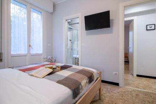 een slaapkamer met een bed en een televisie aan de muur bij AZURE RETREAT Apartment in Camogli