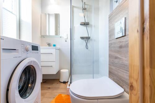 ein Bad mit einer Waschmaschine und einer Dusche in der Unterkunft Będzin Standard Apartment in Będzin