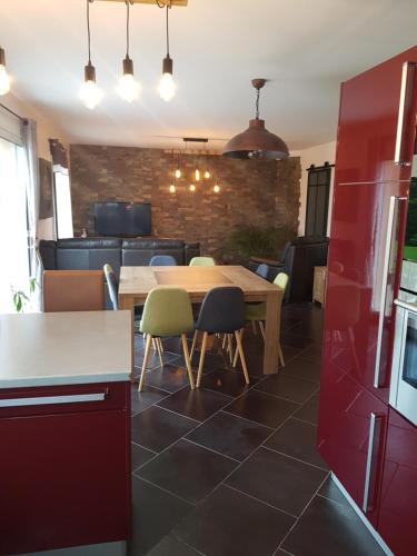 une cuisine avec une table et des chaises en bois dans l'établissement plages du débarquement, à Montebourg