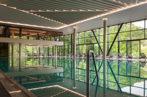 a swimming pool with glass windows and a swimming pool at Verkhovyna Resort Medical & Wellness in Kamenitsa