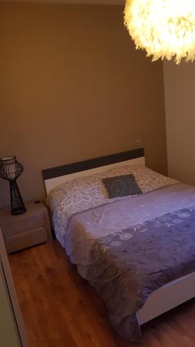 une chambre avec un lit et un lustre dans l'établissement plages du débarquement, à Montebourg