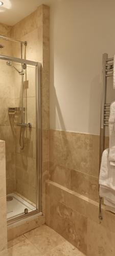 a bathroom with a shower with a glass door at Riverdale Hall Hotel & Leisure in Bellingham