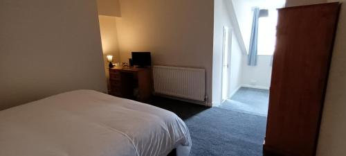 a bedroom with a bed and a desk and a window at Riverdale Hall Hotel & Leisure in Bellingham