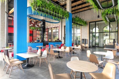 un ristorante con tavoli, sedie e piante di K-Town Resort Phan Thiet a Phan Thiet