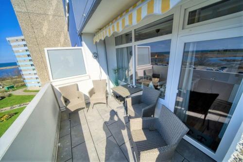 - un balcon d'une maison avec des chaises et une table dans l'établissement Ferienpark - Haus G, App 0G0602, à Heiligenhafen