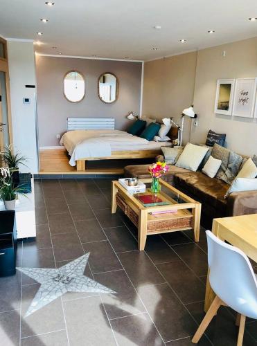 ein Wohnzimmer mit einem Bett und einem Sofa in der Unterkunft Ferienpark - Haus F, App 0F1405 in Heiligenhafen