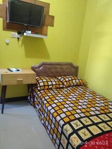 Schlafzimmer mit einem Bett, einem Schreibtisch und einem TV in der Unterkunft Guest House Exclusive Bawen 24 