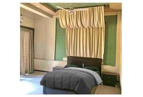 - une chambre avec un lit aux murs verts et une fenêtre dans l'établissement Salt Life villa, à Lonavala